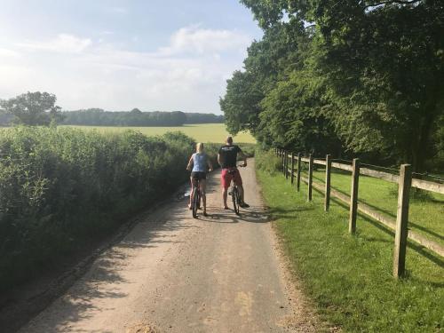 a man and a woman riding bikes down a dirt road at New Acre Pod in Angmering