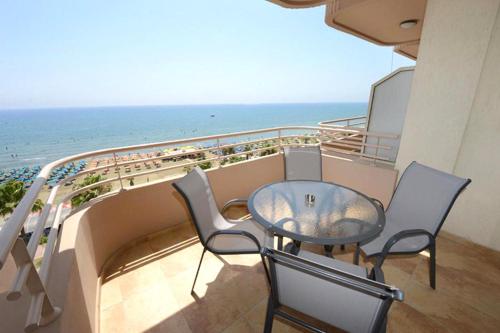 a balcony with a table and chairs and the ocean at Les Palmiers Beach Boutique Hotel & Luxury Apartments in Larnaka