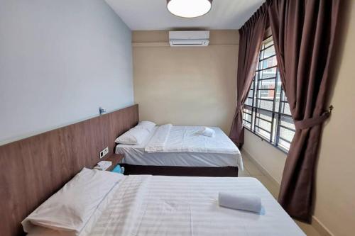 two beds in a hospital room with a window at Comfort home 5min to Airport 15min to city center 近机场 适合小家庭 安静小区 in Penampang