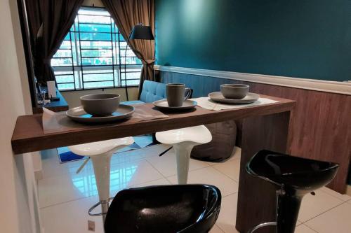 a wooden table with two cups and two stools at Comfort home 5min to Airport 15min to city center 近机场 适合小家庭 安静小区 in Penampang