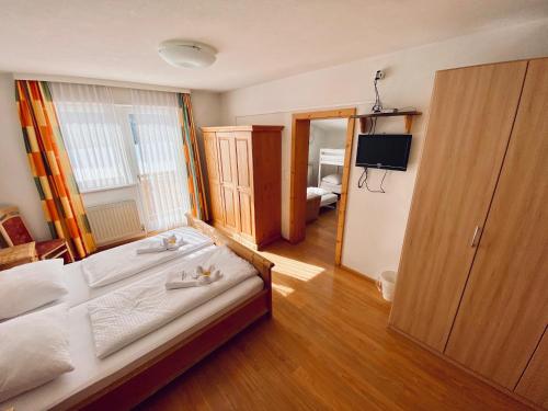 a bedroom with a bed and a television in it at Hotel Kirchdach in Gschnitz