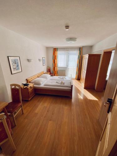 a bedroom with a bed and a wooden floor at Hotel Kirchdach in Gschnitz