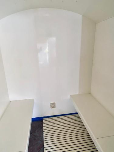 an empty room with white walls and a shelf at Hotel Kirchdach in Gschnitz