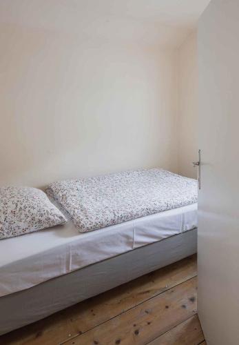 a bed with white sheets and pillows in a room at 2 Chalets Innsbruck in Innsbruck