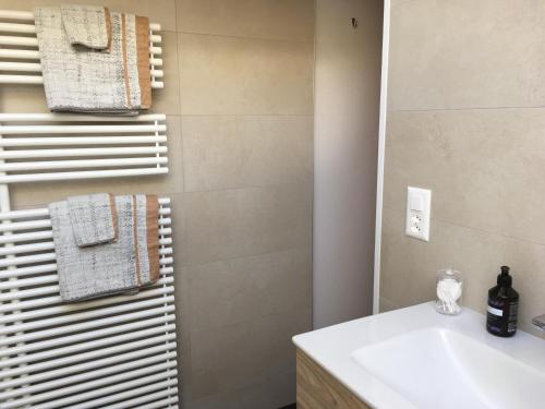 a bathroom with a white sink and a mirror at Chalet-style Apartment with Matterhorn View in Zermatt