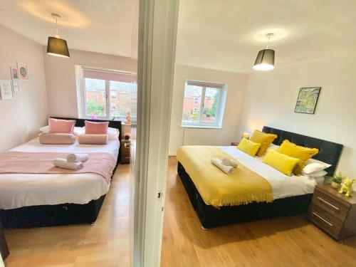 two beds in a bedroom with yellow and pink at Convenient Manchester city centre 3BD with free parking in Manchester