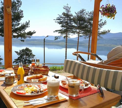 een tafel met borden met voedsel erop met uitzicht op het water bij Villa Santa Maria in Tsigov Chark