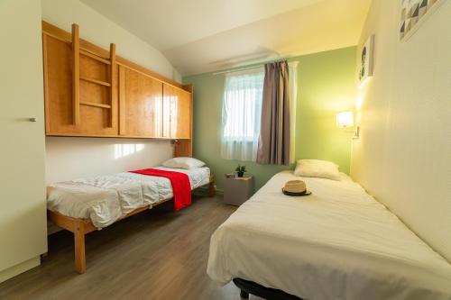 two beds in a small room with green walls at VVF Normandie Forges-les-Eaux in Forges-les-Eaux