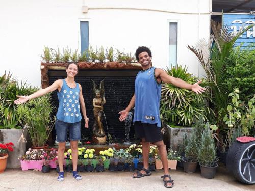 un homme et une femme debout devant une fontaine dans l'établissement MiniResort Chanthaburi, à Chanthaburi