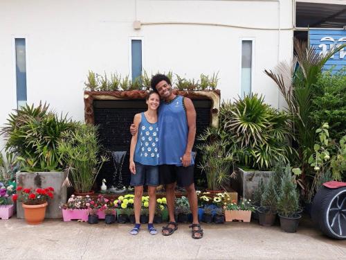mężczyzna i kobieta stojący przed roślinami w obiekcie MiniResort Chanthaburi w mieście Chanthaburi