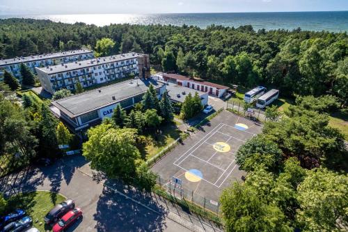 an aerial view of a building with a tennis court at OW Carbo Dąbki - w sąsiedztwie lasu i jeziora in Dąbki