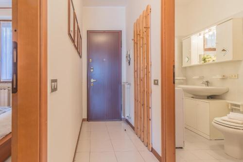 uma casa de banho com uma porta roxa e um lavatório em Patrizia's House Varenna em Varenna