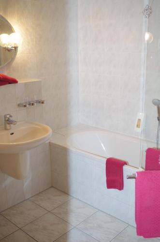 a bathroom with a white tub and a sink at Hotel Zum Abschlepphof in Leipzig