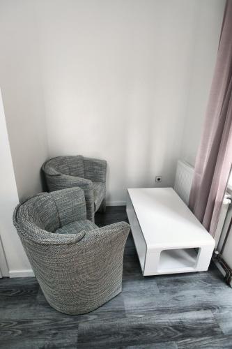 two chairs and a white table in a room at Hotel Kotva in Hřensko