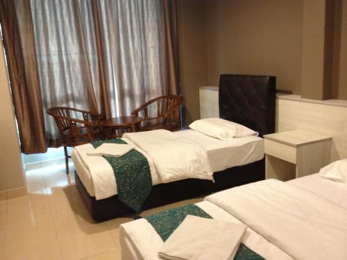 Habitación de hotel con 2 camas y 2 sillas en AERO Star Hotel, en Seremban