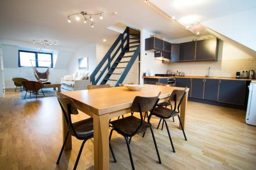 a kitchen and dining room with a wooden table and chairs at Charming Triplex near Avenue Louise in Brussels