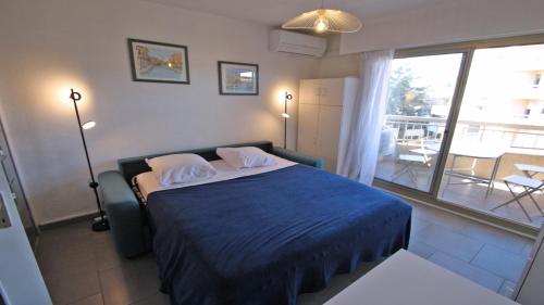 une chambre avec un lit bleu et un balcon dans l'établissement Santa Cruz, à Sainte-Maxime
