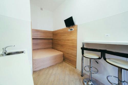 リヴィウにあるApartment on Kulisha 29 -Mini Economy apartments in the central part of Lvivの小さなベッドルーム(ベッド1台、シンク、スツール付)