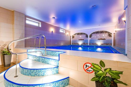 una piscina con azulejos azules en una habitación con piscina en Hotel Amfora, en Viazma