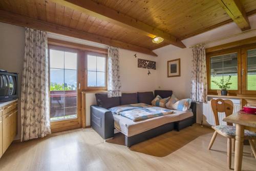 a bedroom with a bed and a couch in a room at Zasserlhof Familie Bamberger in Kössen