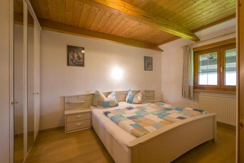 a bedroom with a large bed with a wooden ceiling at Zasserlhof Familie Bamberger in Kössen