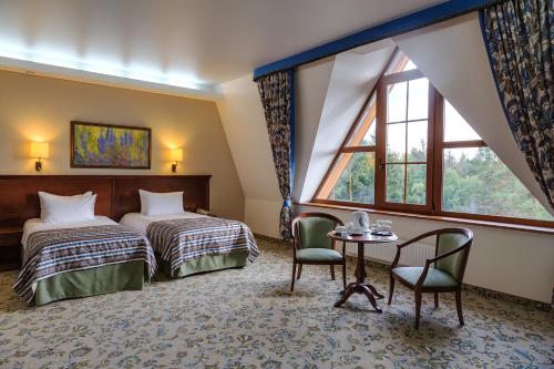een hotelkamer met 2 bedden en een tafel en stoelen bij Areal Congress hotel in Novaya Kupavna