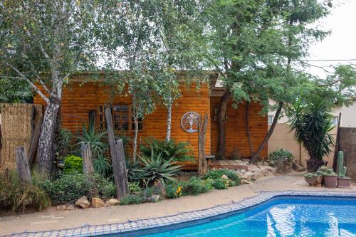 a house with a swimming pool in front of a house at Blyde Africa- Cottage in Benoni