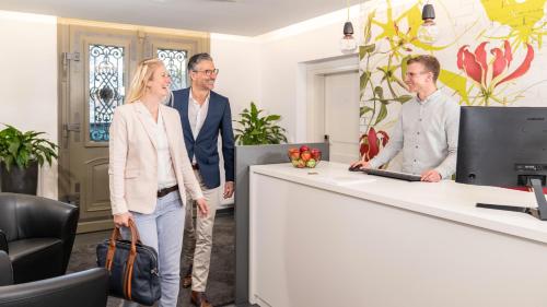 a group of people standing around a reception desk at campuszwei - Hotel & Boardinghouse in Ludwigsburg