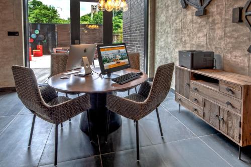 an office with a desk with a laptop and chairs at Hotel Indigo Pittsburgh University - Oakland by IHG in Pittsburgh