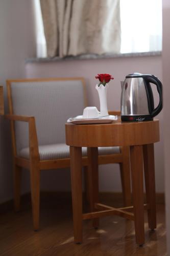a table with a tea kettle and a vase with a flower at New Day Hotel in Addis Ababa