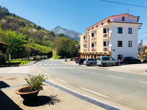 eine leere Straße mit Autos, die an der Seite eines Gebäudes geparkt sind in der Unterkunft HOTEL CARAVIA in Caravia