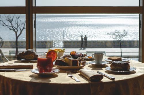 a table with food and a view of the ocean at Hotel Palace in Catanzaro Lido