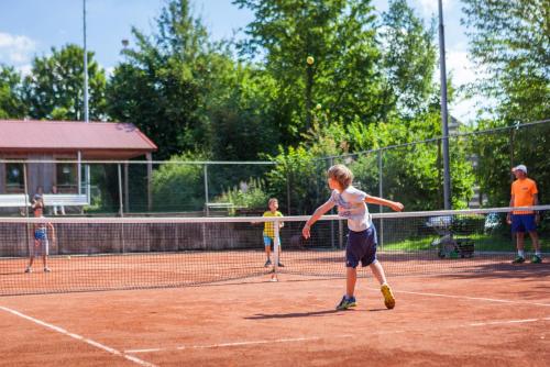 a group of children playing tennis on a tennis court at Buitenplaats De Mechelerhof in Mechelen