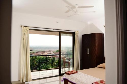 3 BHK Apartment with river view في باناجي: غرفة نوم مع نافذة كبيرة مطلة