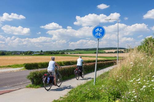 two people riding bikes down a road next to a sign at Buitenplaats De Mechelerhof in Mechelen
