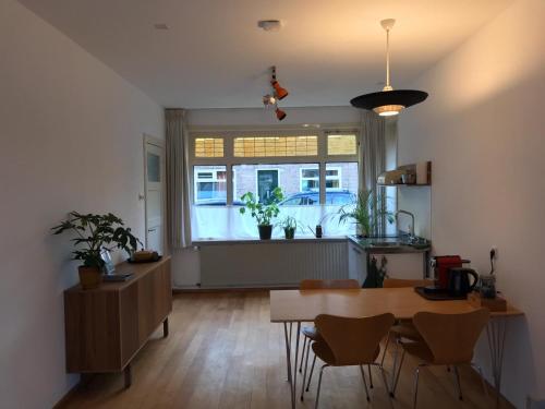 a kitchen with a table and chairs and a window at Huis nummer 1 in Eindhoven