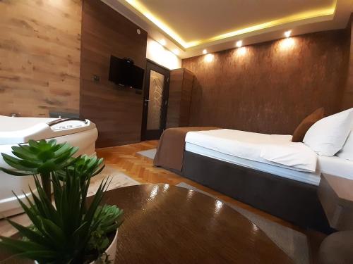 a hotel room with a bed and a sink at Stan na Dan Apartman D Lux Jacuzzi in Kragujevac
