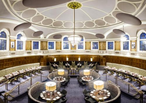 a banquet hall with tables and chairs and a chandelier at Hotel Indigo - Durham by IHG in Durham