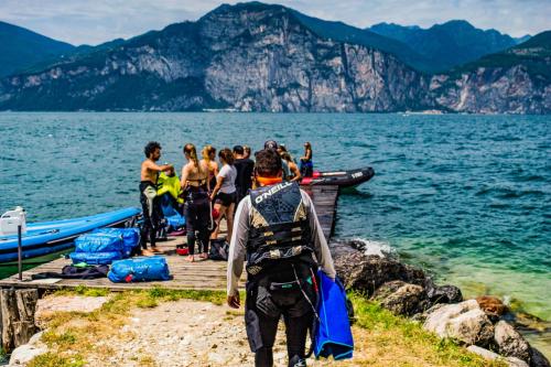 a group of people standing on a dock near the water at Hotel Caribe - Garda Lake Collection in Brenzone sul Garda