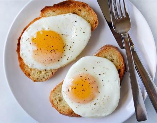 two eggs on toast on a plate with a fork and knife at Akasa Goa in Palolem