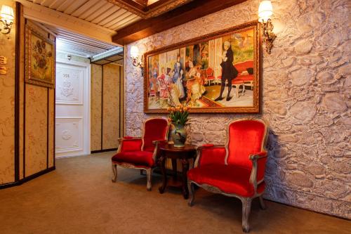a room with a couch, chairs and a painting on the wall at Hotel The Stamp in Den Bosch