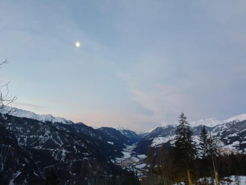 a view of a snowy mountain range with a city at Haus Bergglück in Kaunerberg