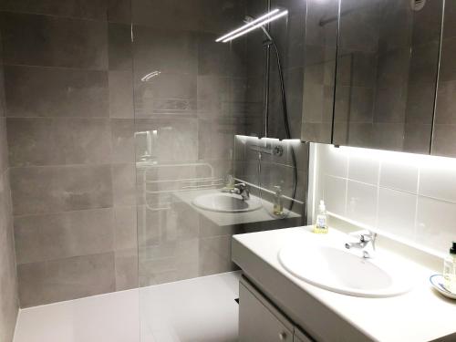 une salle de bain avec deux lavabos et une douche dans l'établissement PALMA T3 confort parking centre, à Arcachon