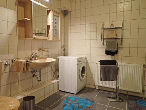 ein Badezimmer mit Waschbecken und Waschmaschine in der Unterkunft Meine Ferienwohnung Seeburg 2 in Seeburg