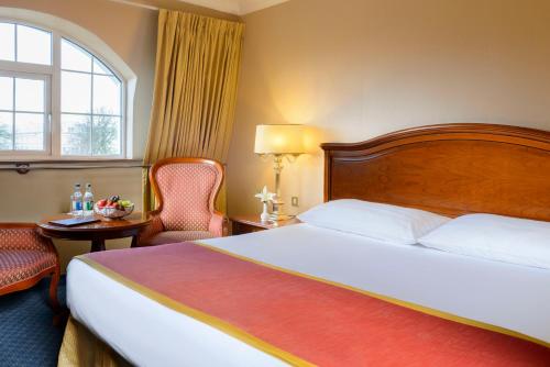 a hotel room with a bed and a chair and a window at Killarney Avenue in Killarney