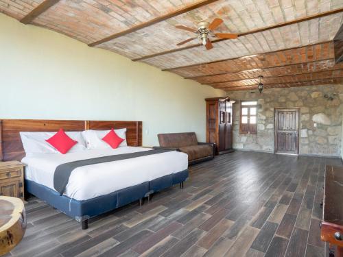 a bedroom with a bed and a ceiling fan at Capital O Hotel Posada Terraza, Tequila Jalisco in Tequila