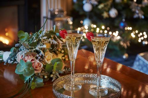 two champagne glasses sitting on a table with a christmas tree at Killarney Avenue in Killarney