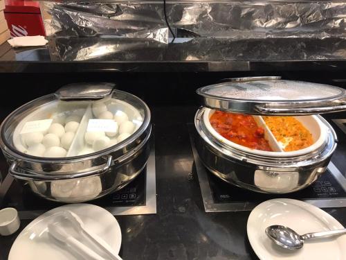 due pentole di cibo appoggiate su un bancone con piatti di Hotel Boursier 2 & Spa a Istanbul