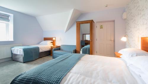 a hotel room with two beds and a couch at Gwesty Gadlys Hotel in Cemaes Bay