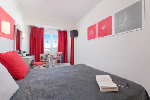 a bedroom with a bed with red curtains and a table at Playas del Rey in Santa Ponsa
